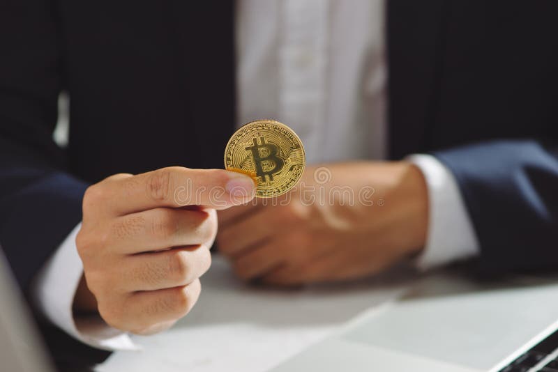 Goldenes Bitcoin in einer Geschäftsmannhand, Digitall-Symbol eines neuen v lizenzfreie stockfotos