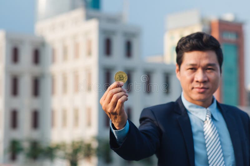 Goldenes Bitcoin in Hand von Geschäftsmann mit schwarzem Anzug lizenzfreie stockfotos
