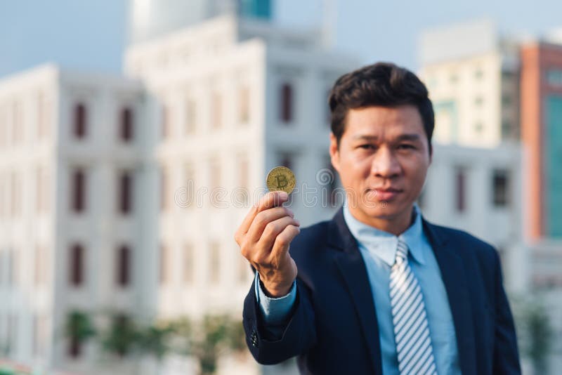Goldenes Bitcoin in Hand von Geschäftsmann mit schwarzem Anzug stockfotos