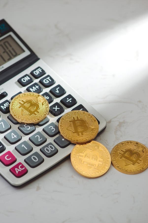 Goldenes bitcoin mit Taschenrechner auf weißem Hintergrund stockfoto