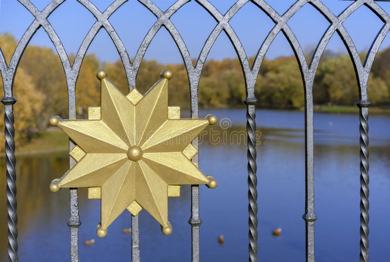 Goldenes dekoratives Element am geschmiedeten Zaun lizenzfreies stockfoto Goldenes dekoratives Element am geschmiedeten Zaun lizenzfreies stockfoto