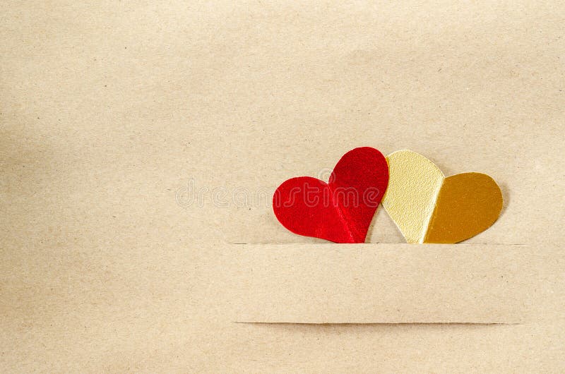 Goldherz und rotes Herz auf braunem Papier der Weinlese stockbild Goldherz und rotes Herz auf braunem Papier der Weinlese stockbild