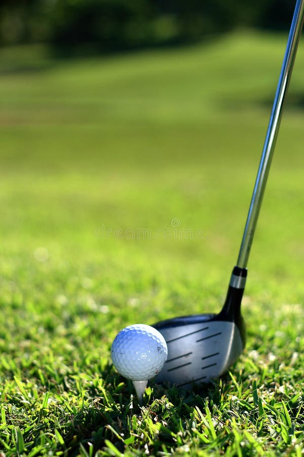 A golf club (driver) about to strike a golf ball on a tee