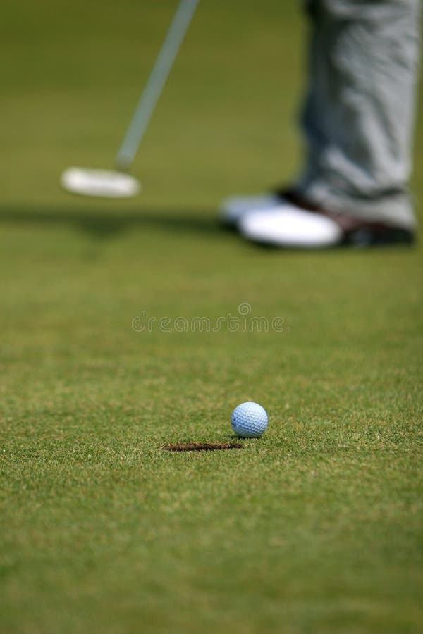 Golfer putting on green with shallow depth of field