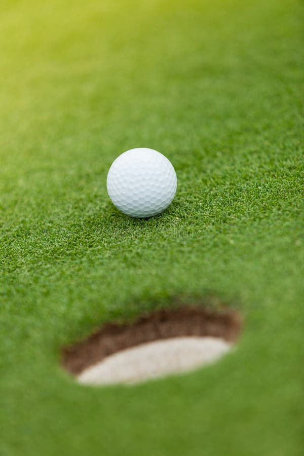 Golf Ball on the Edge of Hole Stock Photo Image of background