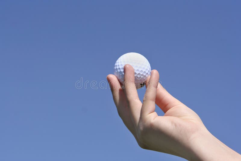 Golf ball in my hand with a bl