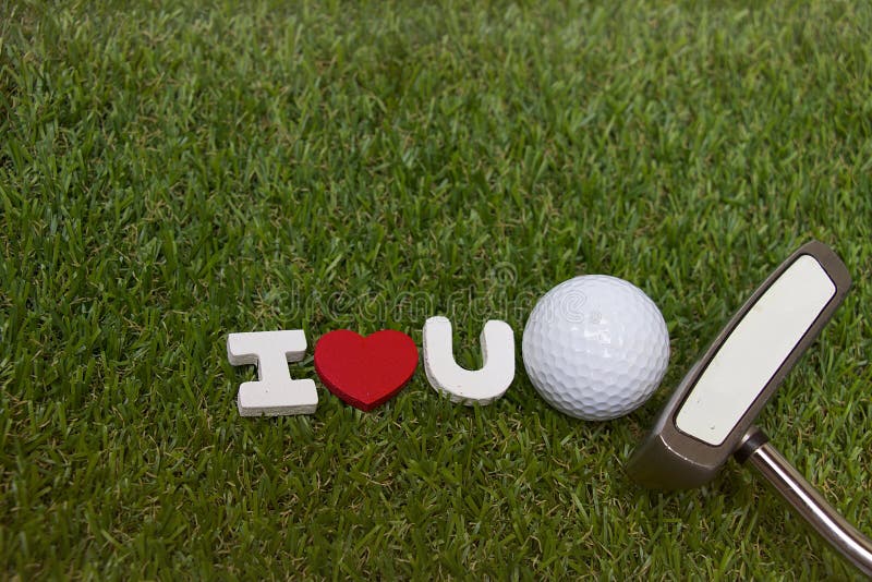 Golf ball and putter with I love you sign on green course