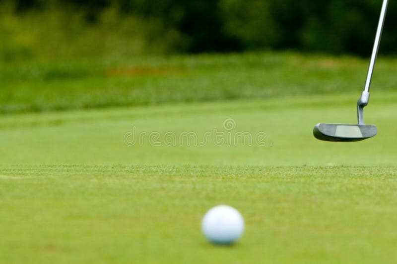 Golf ball and putter near green