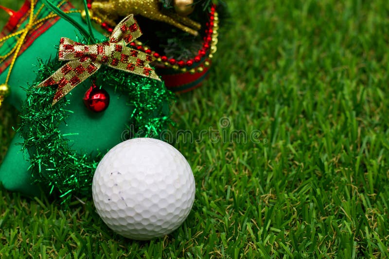 Golf ball with Christmas ornament are on green grass. Golf ball with Christmas ornament are on green grass