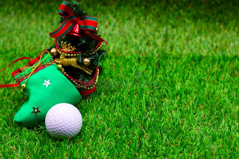 Golf ball with Christmas ornament are on green grass. Golf ball with Christmas ornament are on green grass