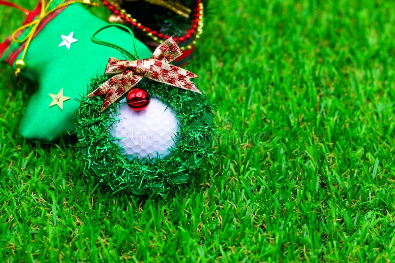 Golf ball with Christmas ornament are on green grass. Golf ball with Christmas ornament are on green grass
