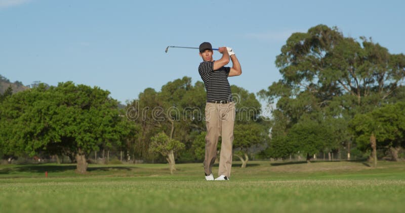 Golf player hitting the ball with his club