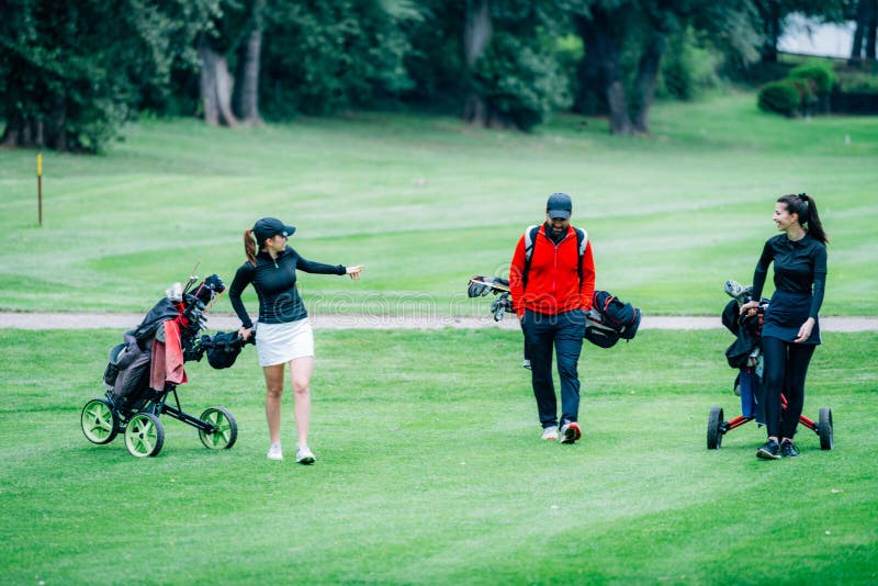 Golf Training. Two Young Ladies with Golf Instructor Having a Lesson on