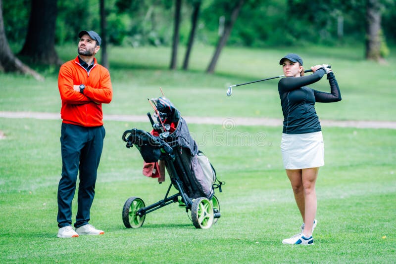 Golf Training. Two Young Ladies with Golf Instructor Having a Lesson on