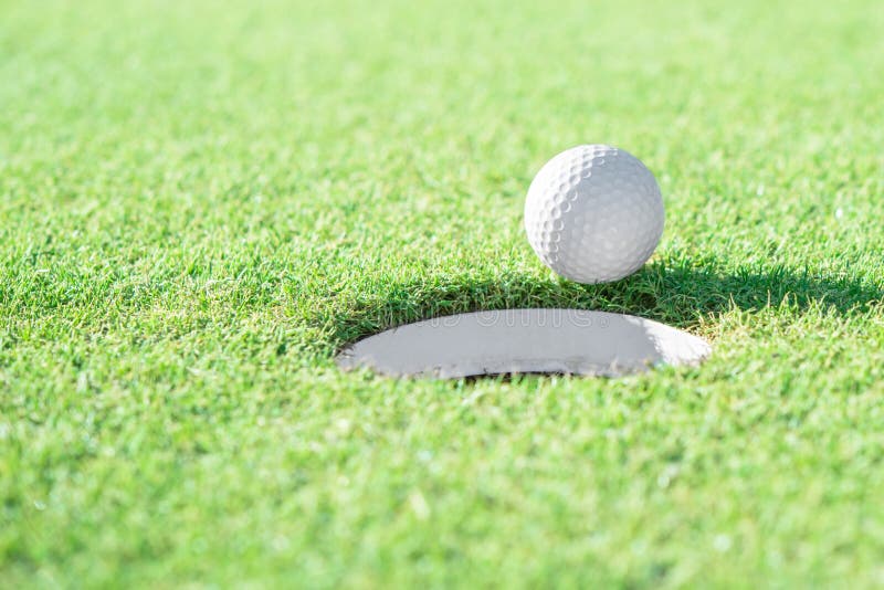 Golfball und Golfloch auf grünem Gras mit Kopienraum lizenzfreie stockfotografie Golfball und Golfloch auf grünem Gras mit Kopienraum lizenzfreie stockfotografie