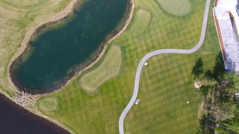Golfbana på en solig dag, en utmärkt golfklubb med damm och grönt gräs, sikt från himlen royaltyfria foton Golfbana på en solig dag, en utmärkt golfklubb med damm och grönt gräs, sikt från himlen royaltyfria foton