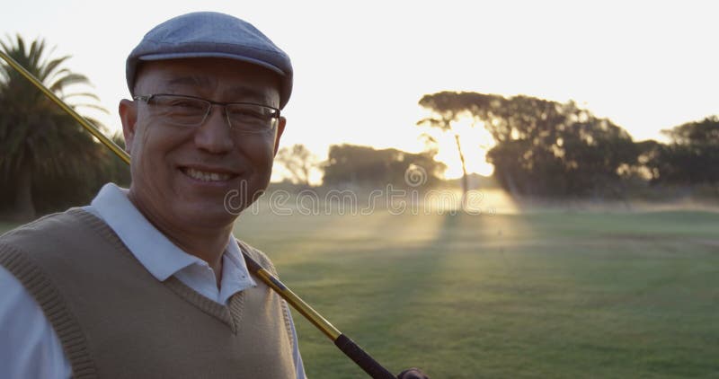 Golfer carrying golf club over shoulder while standing on the golf course