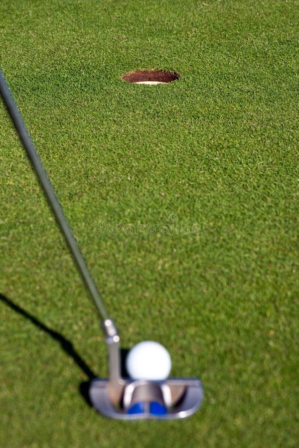 Golfer lining up a short putt - focus on the hole