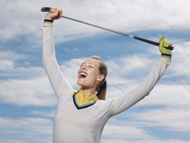 Golfeur féminin tenant le club contre le ciel photographie stock Golfeur féminin tenant le club contre le ciel photographie stock