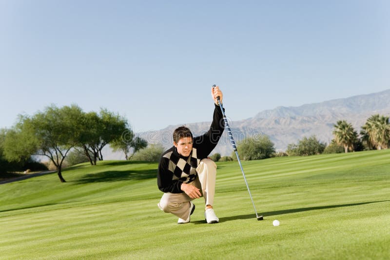 Golfeur masculin alignant le putt photographie stock Golfeur masculin alignant le putt photographie stock