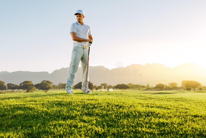 Golfista de sexo masculino con el club de golf en el campo que mira lejos fotografía de archivo Golfista de sexo masculino con el club de golf en el campo que mira lejos fotografía de archivo