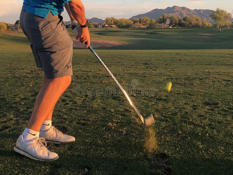 Golfista que golpea una pelota de golf de una visi?n trasera fotografía de archivo Golfista que golpea una pelota de golf de una visi?n trasera fotografía de archivo