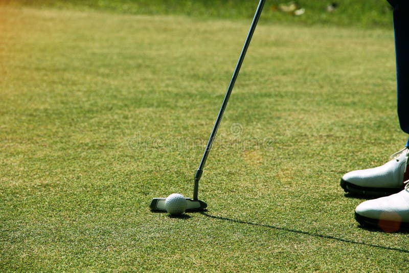Golfista que pone la pelota de golf en el golf verde fotos de archivo libres de regalías Golfista que pone la pelota de golf en el golf verde fotos de archivo libres de regalías