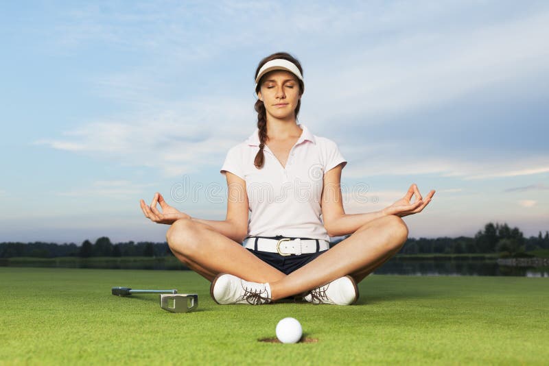 Golfista que se sienta en postura de la yoga en campo de golf. fotografía de archivo libre de regalías Golfista que se sienta en postura de la yoga en campo de golf. fotografía de archivo libre de regalías