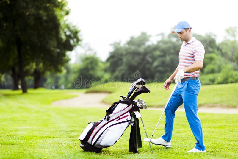 Golfista que selecciona al club apropiado imágenes de archivo libres de regalías Golfista que selecciona al club apropiado imágenes de archivo libres de regalías