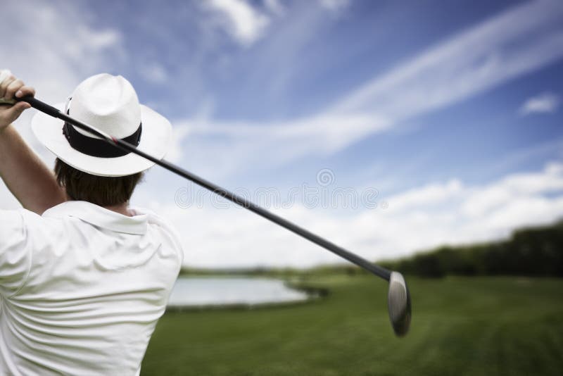 Close-up of male golf player with hat teeing-off at beautiful golf course. Close-up of male golf player with hat teeing-off at beautiful golf course.