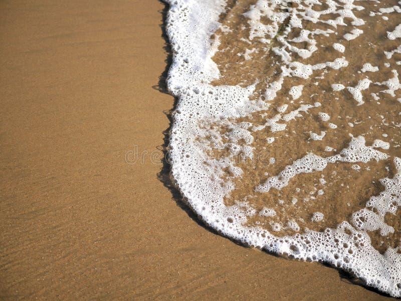 Waves lapping against sand on the California coast. Sea foam and sandy beaches in summer sunlight for travel blogs, website banners, social posts. Waves lapping against sand on the California coast. Sea foam and sandy beaches in summer sunlight for travel blogs, website banners, social posts.