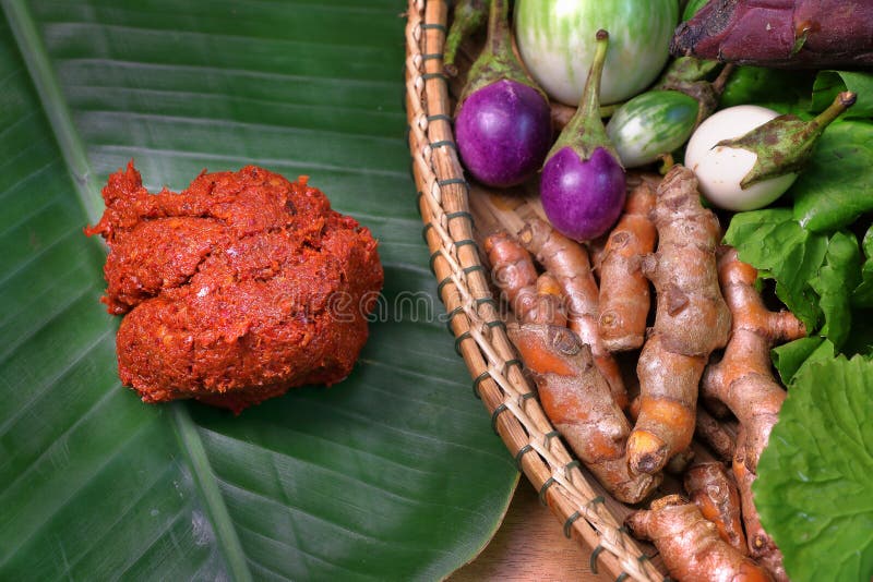 Goma roja del curry en la hoja del plátano con las verduras en la cesta imagen de archivo libre de regalías Goma roja del curry en la hoja del plátano con las verduras en la cesta imagen de archivo libre de regalías