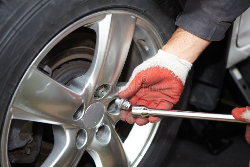 Meccanico che cambia una gomma immagine stock libera da diritti