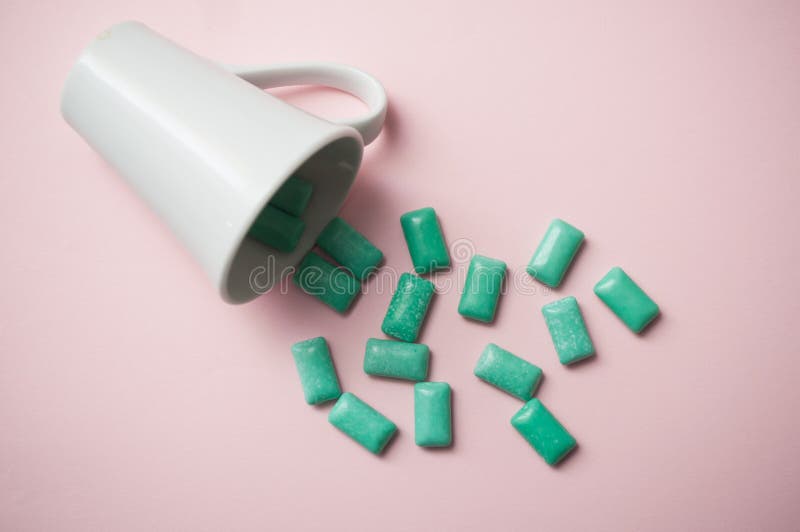 gomma da masticare della menta piperita che cade da una tazza bianca sul pi immagini stock gomma da masticare della menta piperita che cade da una tazza bianca sul pi immagini stock