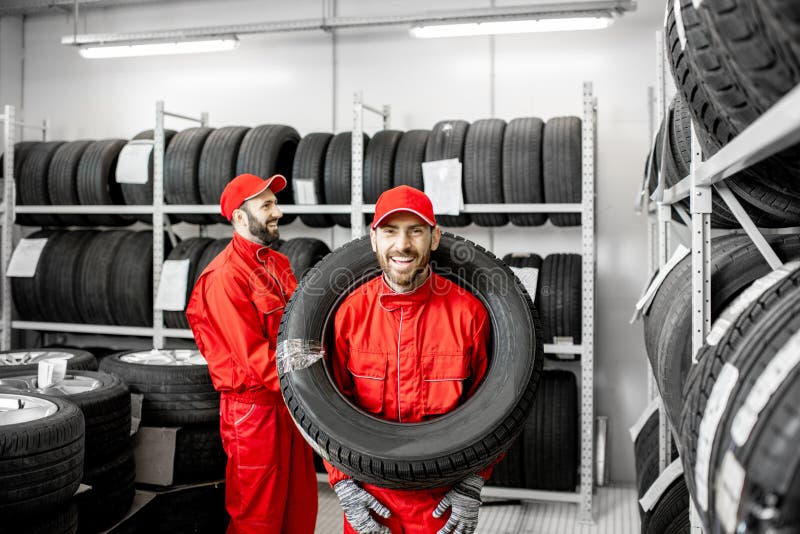 Gomma di automobile d'uso del lavoratore nello stoccaggio immagini stock libere da diritti Gomma di automobile d'uso del lavoratore nello stoccaggio immagini stock libere da diritti
