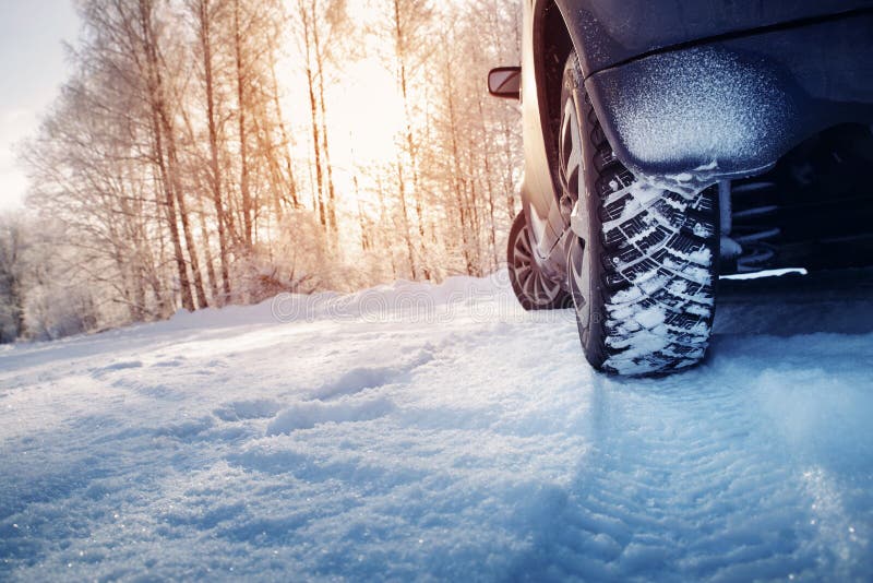Gomme di automobile sulla strada di inverno coperta di neve fotografia stock