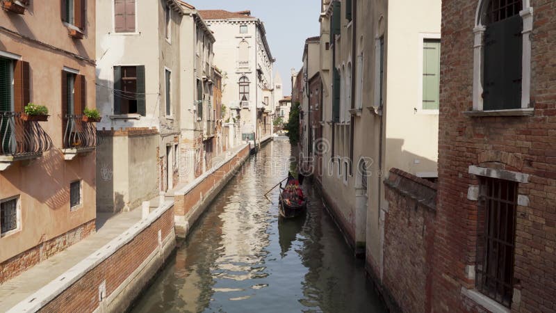 Gondole à ramer se rapprochant sur un canal étroit à venise italie banque de vidéos