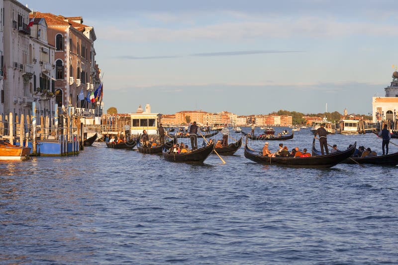 Gondoliers Венеции на гондолах с туристами на грандиозном канале на заходе солнца, Венеции, Италии стоковые фотографии rf Gondoliers Венеции на гондолах с туристами на грандиозном канале на заходе солнца, Венеции, Италии стоковые фотографии rf