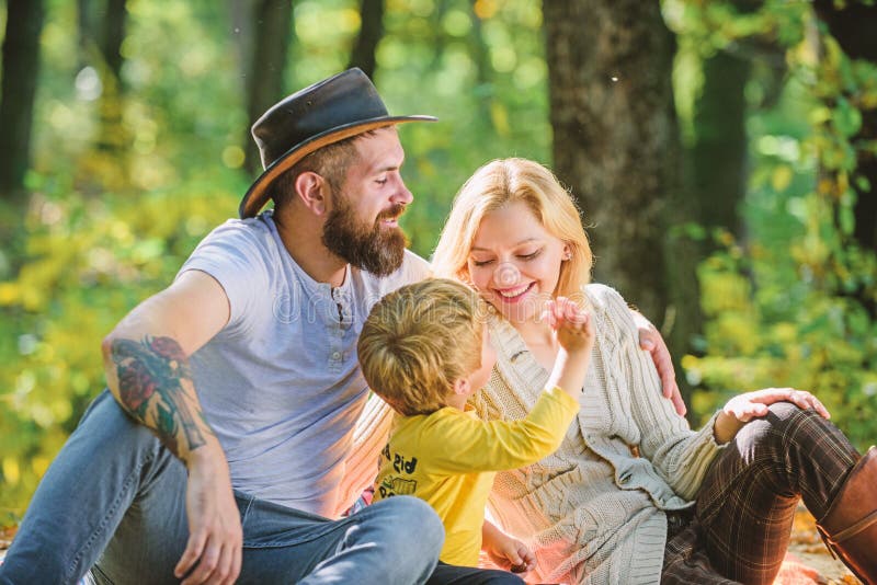 Good day for spring picnic in nature. Explore nature together. Family day concept. Mom dad and kid boy relaxing while hiking in forest. Family picnic. Mother father and little son sit forest picnic.