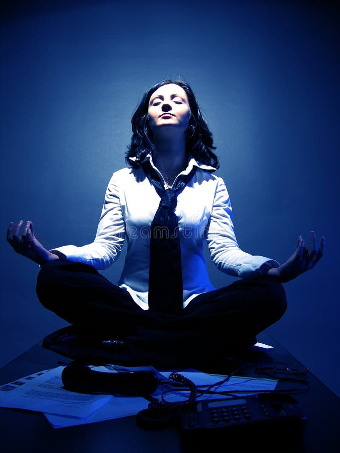 An attractive businesswoman in lotus position, invoking good karma over the business. An attractive businesswoman in lotus position, invoking good karma over the business.