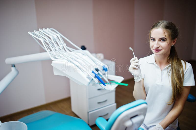 Good Looking Female Dentist Posing With Some Dental Instruments In Her