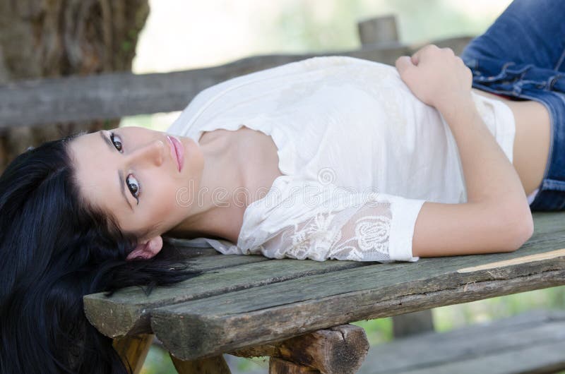 Good looking woman lie on a wooden table