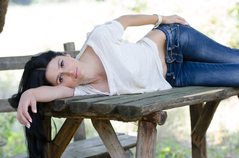 Good looking woman lie on a wooden table