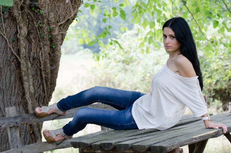 Good looking woman sitting on a wooden table