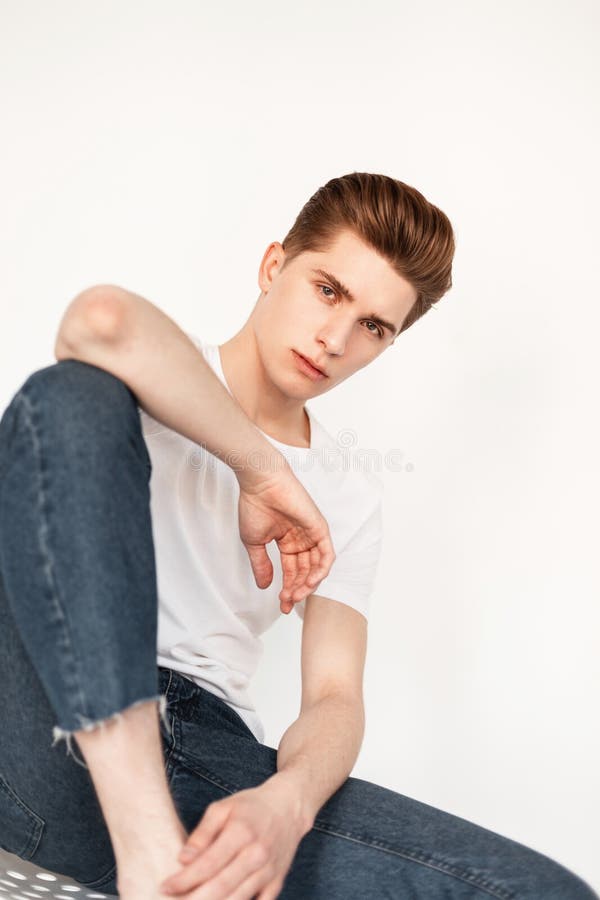 Premium Photo | Attractive young man with hairstyle in stylish pink t-shirt  in fashionable denim jacket posing near vintage wooden brown wall in  street. european handsome guy model in jeans clothes is