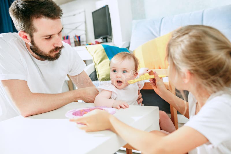 Bene cercando giovane uomini mangiare colazione un alimentazione suo un bambino sul.