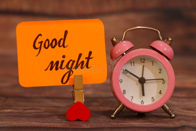 Good Night text attached with heart clip and alarm clock. royalty free stock image Good Night text attached with heart clip and alarm clock. royalty free stock image