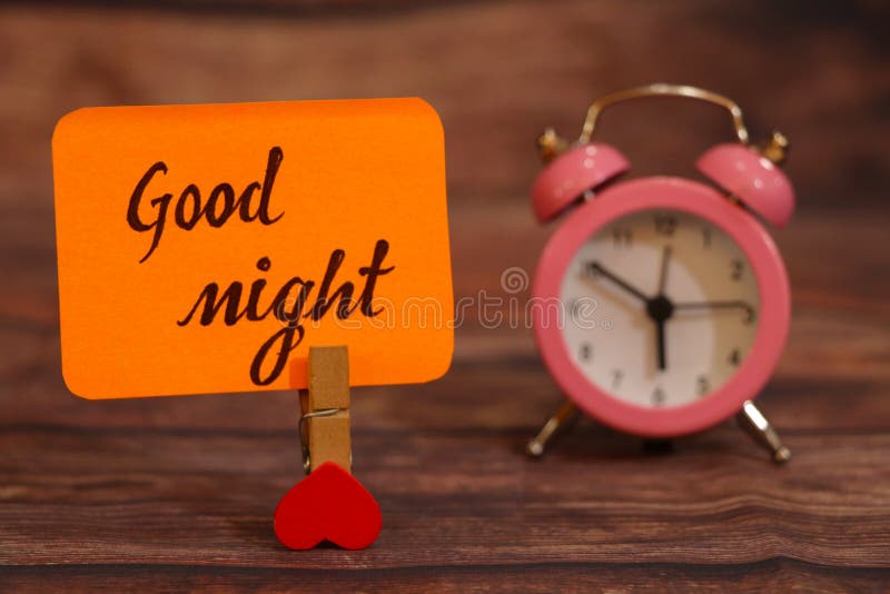 Good Night text attached with heart clip and alarm clock. royalty free stock photos Good Night text attached with heart clip and alarm clock. royalty free stock photos