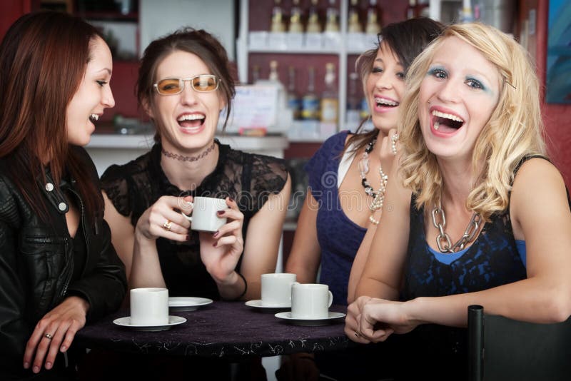 Pretty young blonde laughing with three friends in a cafe. Pretty young blonde laughing with three friends in a cafe