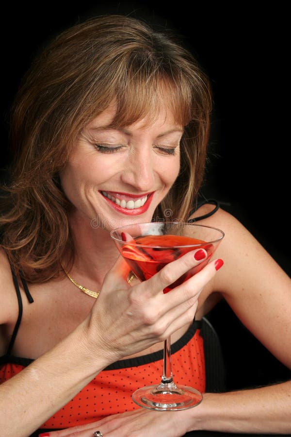 A beautiful woman laughing over a coctail. A beautiful woman laughing over a coctail.